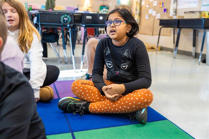 A teacher plays a ukulele for her students